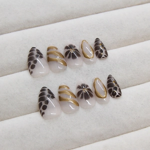 Elegant almond press-on nails with black floral and leopard patterns on beige velvet base