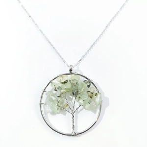 Detail of tree of life pendant with green natural crystals and silver wire wrap