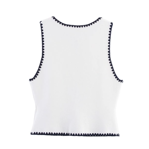 Women's knit vest in white with black contrast scalloped edges and textured knit fabric