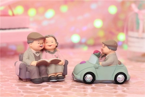Miniature elderly couple figurines reading on sofa and driving a vintage car decor