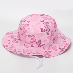 Détail d'un chapeau bob rose pour enfant avec motifs papillons et cordon coupe-vent réglable