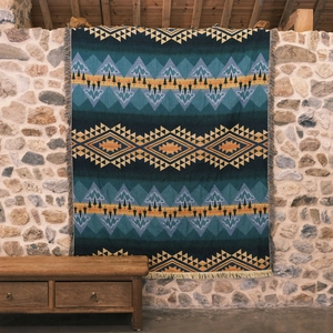 Detail showing the Southwestern geometric woven texture and fringe edges of the blanket