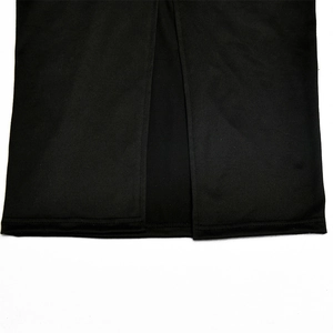 Detail shot of the back slit on a black bodycon dress hem with smooth fabric finish