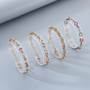 Detailed close-up of 18K gold Cuban link bracelets with vibrant colorful enamel drip accents