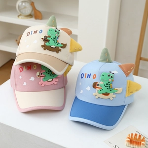Gros plan détaillé des écussons dinosaures 3D et des broderies sur les casquettes enfants