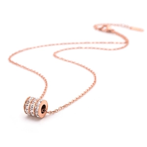 Rose gold cylinder necklace with three rows of sparkling clear crystals on white background