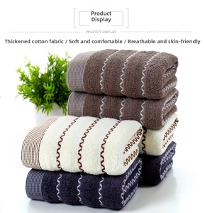 Detail of soft thick cotton towels in brown, cream and grey with zigzag embroidery