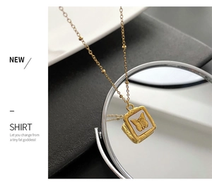 Detail of golden butterfly necklace with square shell pendant and bead chain accents