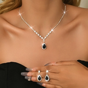 Detailed view of silver necklace and earrings set featuring black teardrop stones