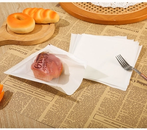 Detail of oil-proof white toast paper bags with transparent window on a newspaper background
