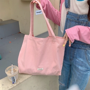 Pink canvas tote bag shown in an outdoor lifestyle setting with large capacity
