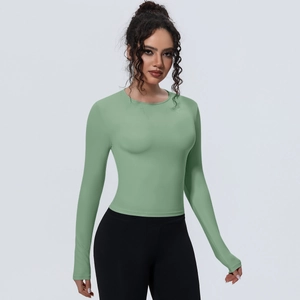 Gros plan du haut de sport vert sauge ajusté en tissu respirant à haute élasticité