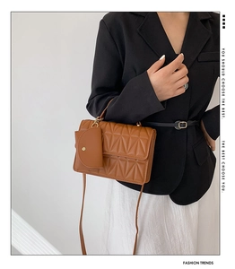 Detail view of brown quilted crossbody bag with a small detachable round coin purse