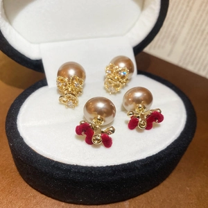 Detail of red flocked heart and champagne pearl earrings in a black gift box
