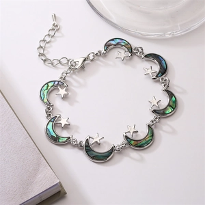 Detail of silver star and moon link bracelet with iridescent abalone shell inlays
