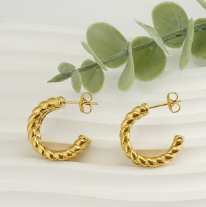 Detailed view of gold C-shaped twisted rope earrings with 18k finish on white background