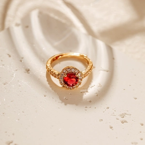 Macro detail of a 18K gold plated ring featuring a red gemstone with halo zircon setting