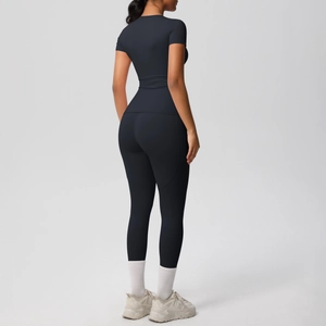 Rear view of tight-fitting black yoga set including short sleeve top and matte leggings