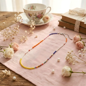 Handmade colorful seed bead necklace with silver lobster clasp on a vintage pink background