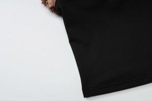 Détail de l'ourlet en maille noire avec coutures fines et accent de fourrure brune