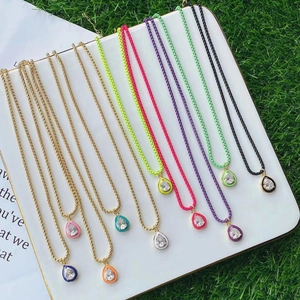 Close-up of vibrant enamel teardrop pendants with clear zircon on gold box chains