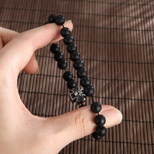 Matte black agate beaded bracelet for men featuring a silver cross and skull charm detail