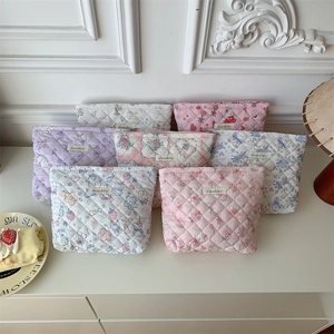 Close-up of quilted makeup bags featuring strawberry and bunny prints in pastel colors