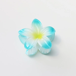 Close-up of a blue gradient plumeria hair claw clip with detailed resin petals and texture