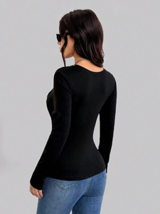 Slim fit black long sleeve knit top with draped neckline and open back detail
