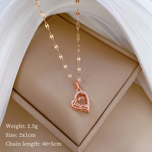 Detail of rose gold heart pendant with Love engraving and zircon inlay on jewelry box