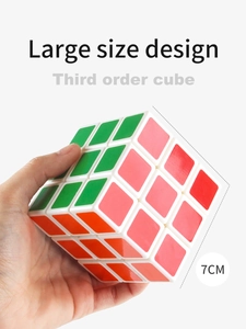 Detail showing hand holding 7cm large 3x3 speed cube with white frame and standard colors