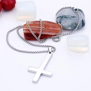 Detailed view of silver cross pendant on box chain with natural decorative stones