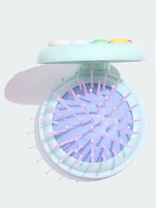 Detailed view of a mint green foldable hairbrush with pink bristles and colorful accents