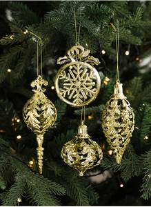 Set of four gold Christmas ornaments featuring intricate cut-out patterns and metallic finish