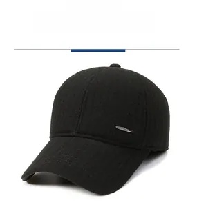 Close-up of black wool baseball cap with silver metal feather accent and warm texture