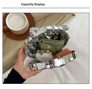 Silver metallic crossbody bag interior showing capacity for cosmetics and chain strap