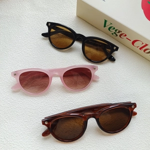 Macro shot of stylish cat eye sunglasses with heart studs in black, pink, and tortoiseshell