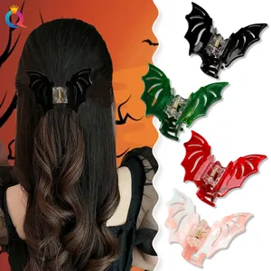 Detail view of glittery bat-shaped claw clips in black, green, red and pink marble colors