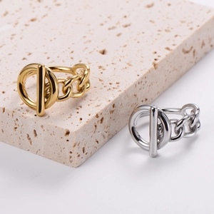 Polished OT toggle chain ring in gold and silver finish on stone display pedestal