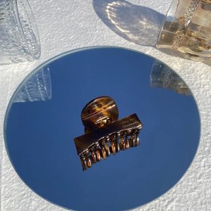 Close-up of tortoise shell hair claw clip reflected on a mirror in a lifestyle setting