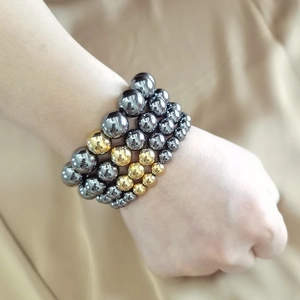 Detail of four-layer magnetic hematite stretch bracelets with silver and gold beads