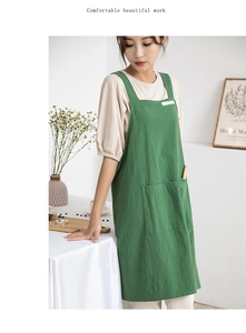 Detail view of a green cotton linen apron with a large pocket in a natural home setting