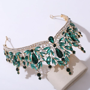 Detail shot of a golden bridal crown with emerald green stones and sparkling crystals