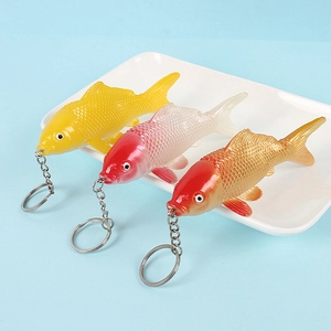 Realistic PVC koi fish keychains in yellow and red-white colors on a light blue background