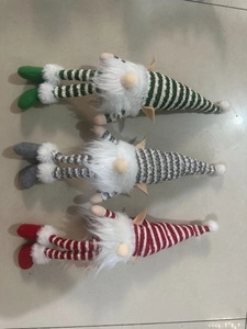 Three plush Christmas gnomes with sparkling striped hats and long white beards in detail