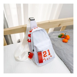Vue détaillée du sac bandoulière blanc pour enfants en nylon avec sangles oranges