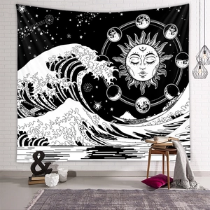 Close-up of black and white bohemian tapestry with sun, moon, and wave motifs on wall