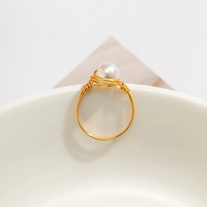 Detail of handmade gold wire-wrapped ring featuring a lustrous round white pearl accent