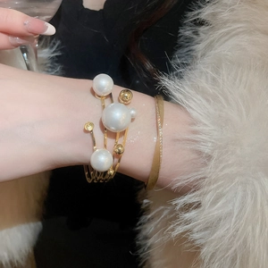 Close-up of elegant gold multi-layer pearl bracelet worn on wrist for formal social events