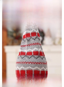 Detailed view of the knitted Christmas wine bottle cap featuring festive snowflake patterns